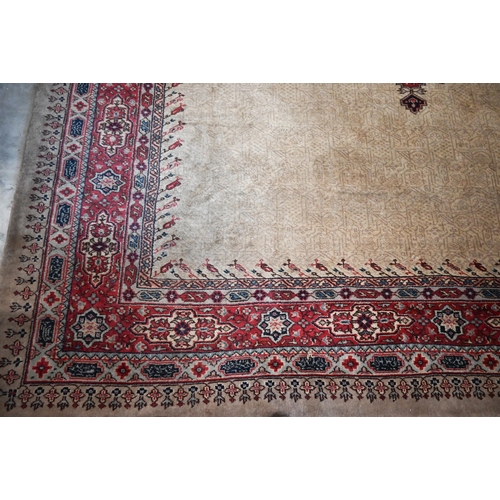 384 - A large Turkish Isparta camel ground carpet, with central diamond medallion and red border, 387 x 27... 