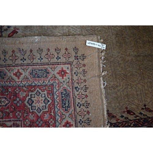 384 - A large Turkish Isparta camel ground carpet, with central diamond medallion and red border, 387 x 27... 