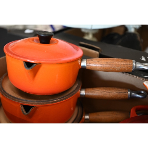 101 - A graduated set of three Le Creuset Flame lipped saucepans with lids, to/w two matching graduated gr... 