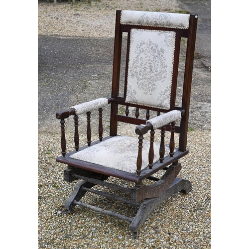 110 - # An Edwardian walnut framed rocking armchair with fabric panelled back and seat