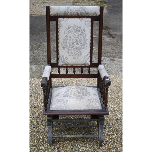 110 - # An Edwardian walnut framed rocking armchair with fabric panelled back and seat