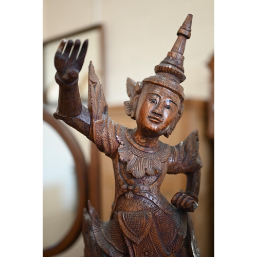 141 - Two Burmese carved wood figures of Temple dancers, 66 cm high