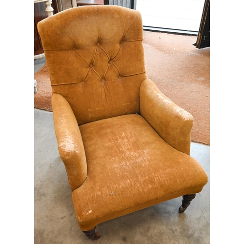 190 - A Victorian armchair with worn velvet cover, on turned mahogany supports with brass and ceramic cast... 