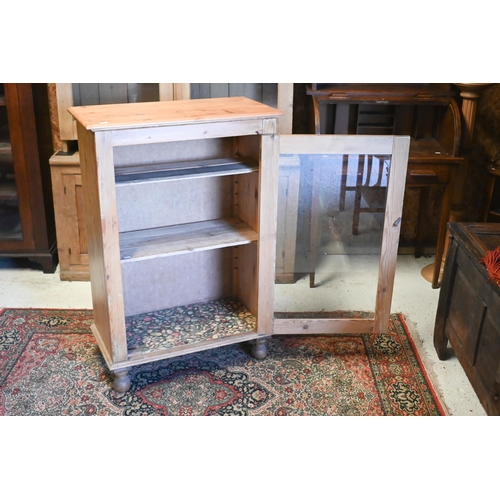 216 - A pine cabinet with single glazed door, raised on turned feet, 73 cm x 36 cm x 107 cm h