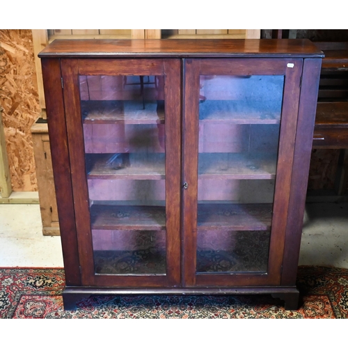 227 - A mahogany twin glazed door bookcase raised on shaped bracket feet, 109 cm x 28 cm x 122 cm h