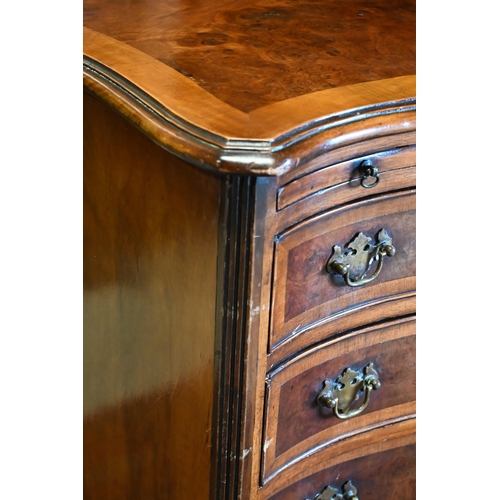 251 - A reproduction cross-banded walnut small serpentine form four drawer chest, with brush slide, 63 cm ... 