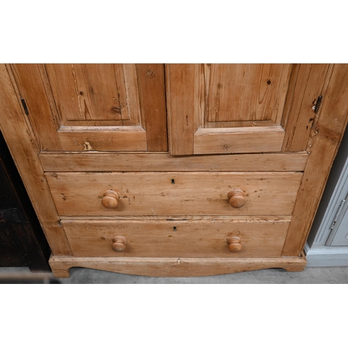 263 - A waxed pine cupboard with panelled cupboards over two drawers, 110 cm wide x 55 cm deep x 162 cm hi... 