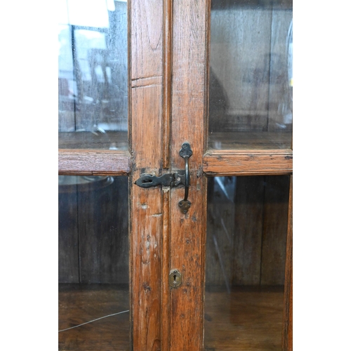 275 - A rustic stained hardwood cabinet with glazed doors (one pane cracked), 120 cm wide x 50 cm deep x 1... 