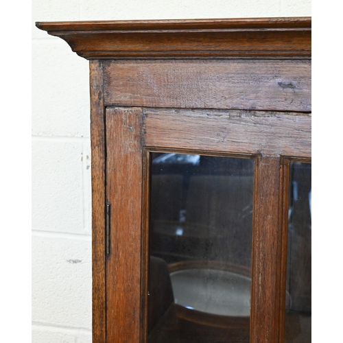 275 - A rustic stained hardwood cabinet with glazed doors (one pane cracked), 120 cm wide x 50 cm deep x 1... 