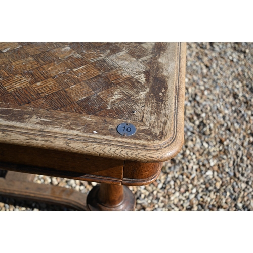 288 - A 19th century French oak dining table with parquetry top, turned supports united by curved stretche... 