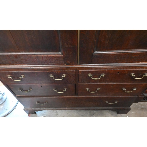 364 - A 19th century oak linen press, the panelled doors enclosing five slides on base with five drawers r... 