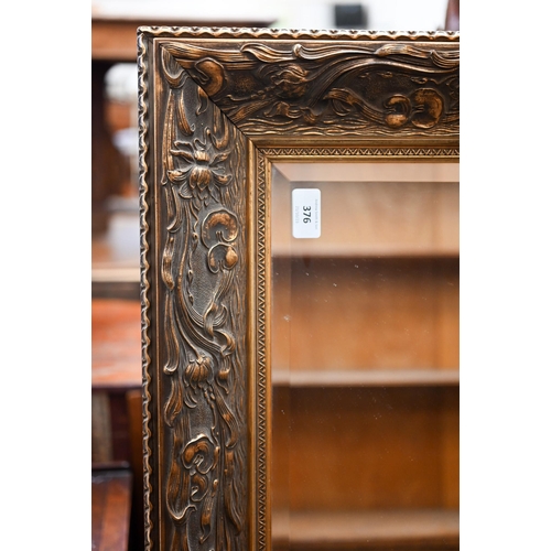 376 - A large bevelled mirror with foliate gilded wood and composite frame, 134 x 102 cm