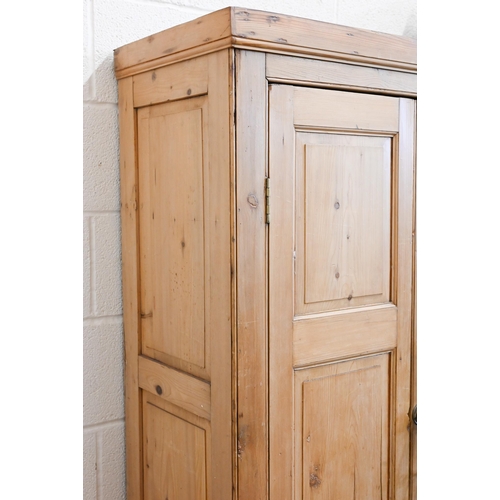 380 - A waxed pine cupboard with panelled doors enclosing fixed shelves, c/w key, 90 x 40 x 170 cm high