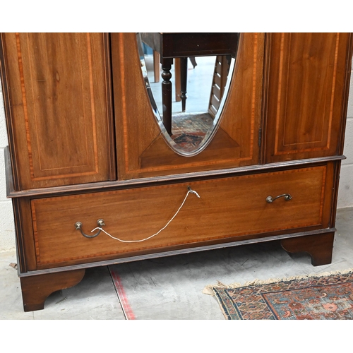 383 - Edwardian walnut and satin-banded wardrobe, the single door inset with bevelled oval mirror on base ... 