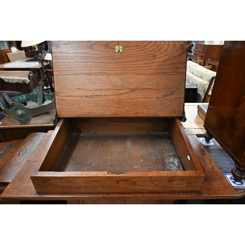 410 - A mid 20th century oak clerk's desk with hinged sloped top on a panelled base with high chair, 98 cm... 