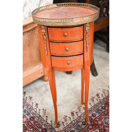 418 - A reproduction French kingwood inlaid oval side table with pierced brass gallery and three drawers, ... 