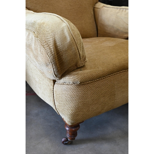 423 - A mahogany framed upholstered armchair on turned front legs with casters, 90 cm d x 85 cm w x 77 cm ... 