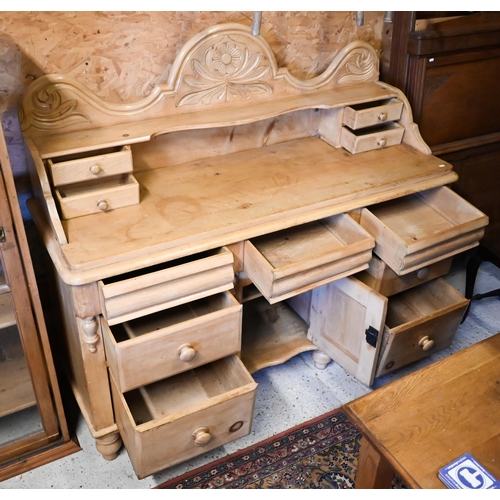 448 - An antique stripped pine gallery backed sideboard, with an arrangement of seven drawers around a cen... 