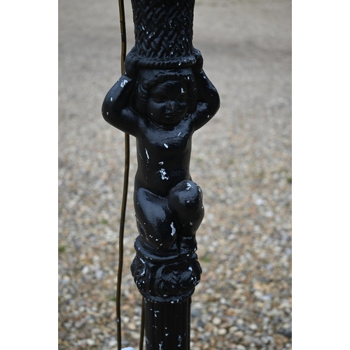 515 - # An ebonised wood standard lamp, carved with a cherub standard lamp, 183cm