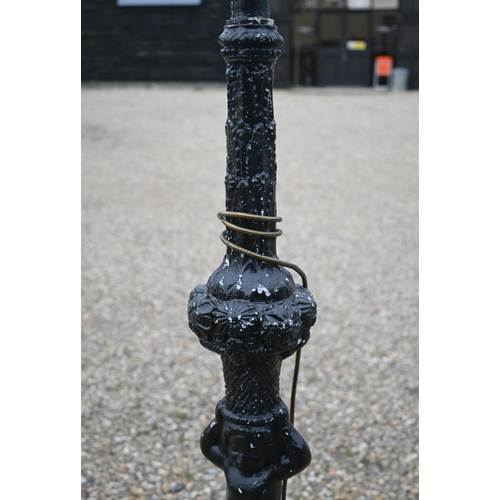 515 - # An ebonised wood standard lamp, carved with a cherub standard lamp, 183cm