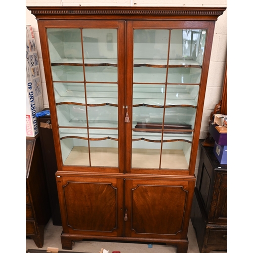 62 - A 19th century mahogany cabinet bookcase with glazed doors over panelled cupboards on bracket feet, ... 