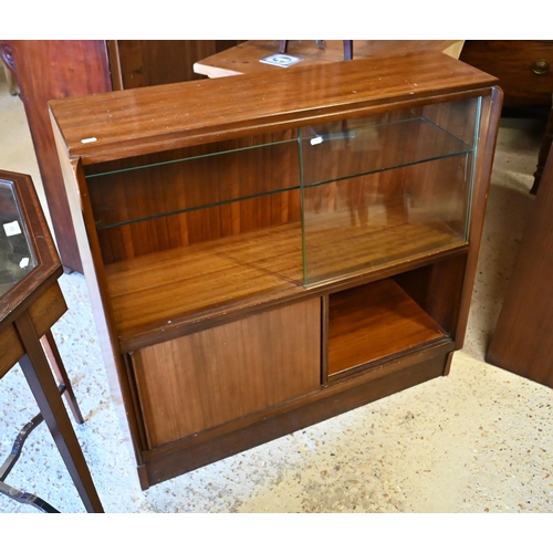 135 - # A companion pair of mid-century slope fronted teak cabinets with glass sliding doors, one with cup... 