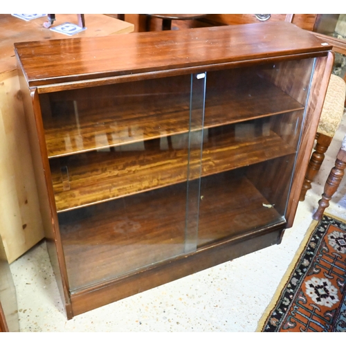 135 - # A companion pair of mid-century slope fronted teak cabinets with glass sliding doors, one with cup... 