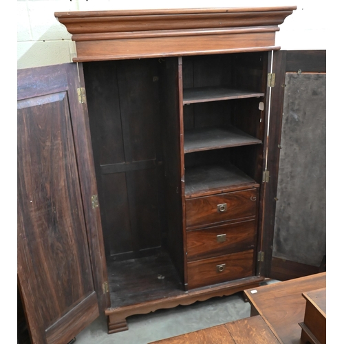 101 - An Indian rosewood compactum wardrobe with full length mirrored and panelled doors enclosing hanging... 