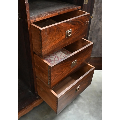 101 - An Indian rosewood compactum wardrobe with full length mirrored and panelled doors enclosing hanging... 