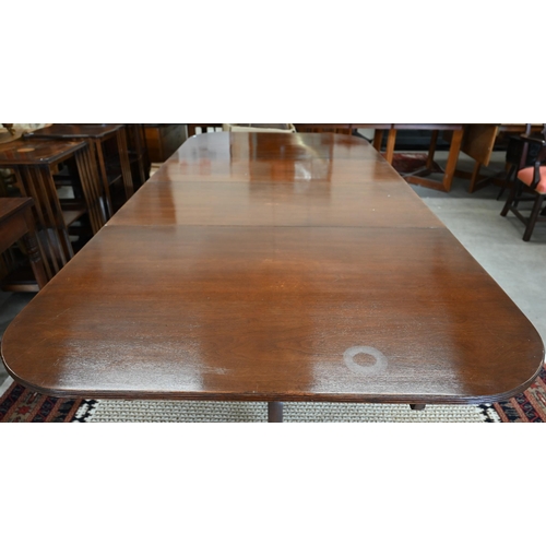 28 - A Regency style mahogany extending dining table with three central leaves on twin pedestal supports ... 