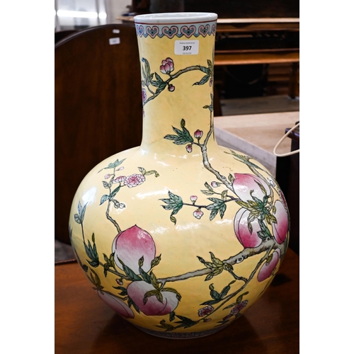 397 - A large Chinese porcelain bottle vase, painted with peaches, flowering prunus and bats, on a yellow ... 