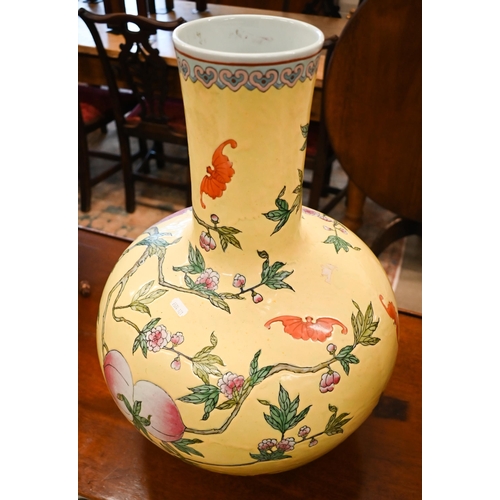 397 - A large Chinese porcelain bottle vase, painted with peaches, flowering prunus and bats, on a yellow ... 