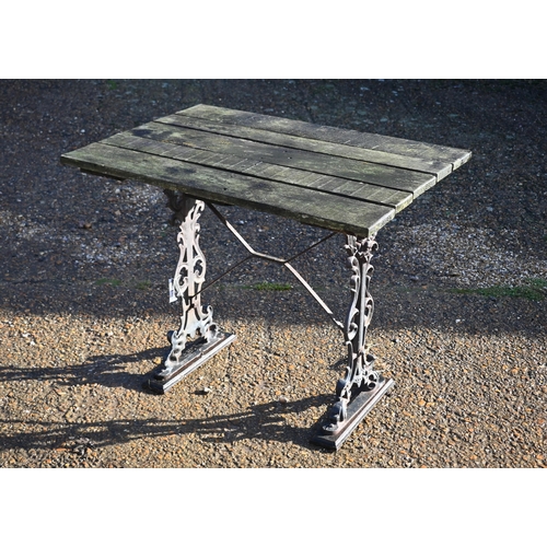 415 - A weathered teak and cast iron garden table, 90 cm wide x 66 cm deep x 72 cm high to/w a somewhat si... 