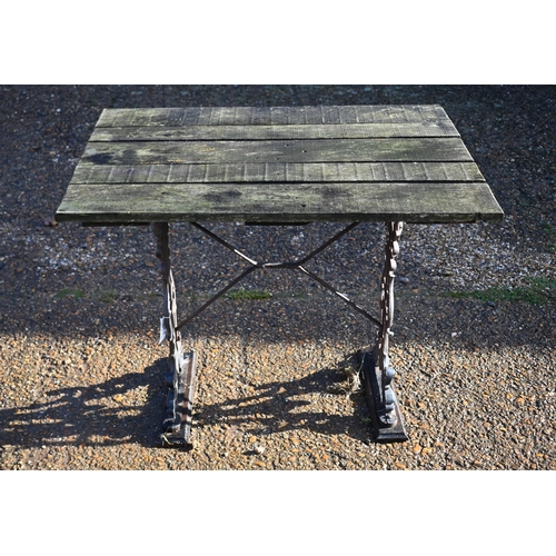 415 - A weathered teak and cast iron garden table, 90 cm wide x 66 cm deep x 72 cm high to/w a somewhat si... 