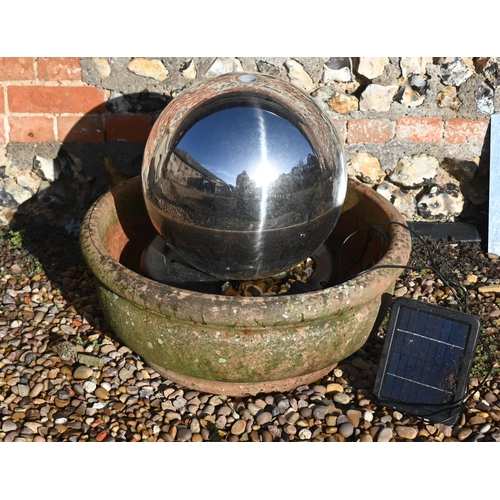 429 - A contemporary stainless steel solar panelled spherical water feature in weathered terracotta bowl