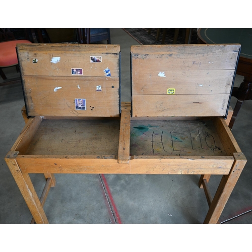 45 - A vintage beech double school desk with twin-hined panelled top, 108 cm wide x 40 cm deep x 66 cm hi... 