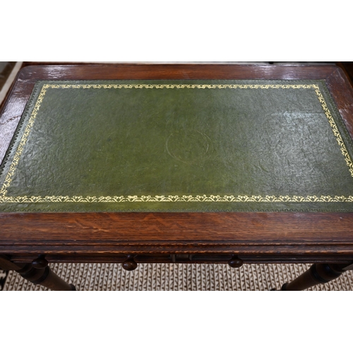 46 - An oak two drawer writing table with tooled green leather top and turned supports on casters, 92 cm ... 