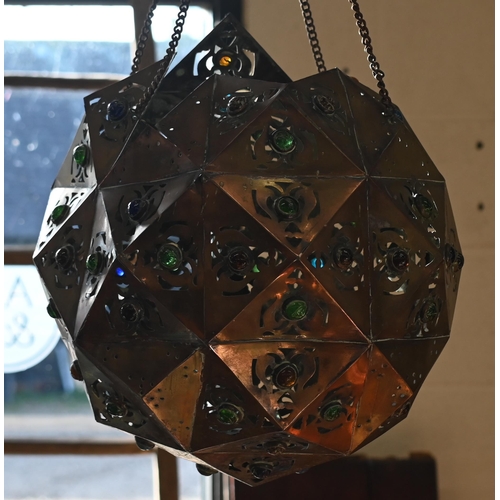 466 - A Middle Eastern pierced copper ceiling lightshade of faceted globular form, set with coloured glass... 