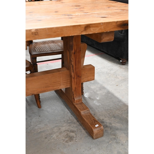 51 - A substantial waxed pine refectory dining table with four-plank rectangular top on twin trestle supp... 