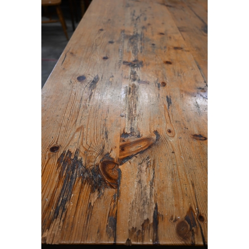 51 - A substantial waxed pine refectory dining table with four-plank rectangular top on twin trestle supp... 