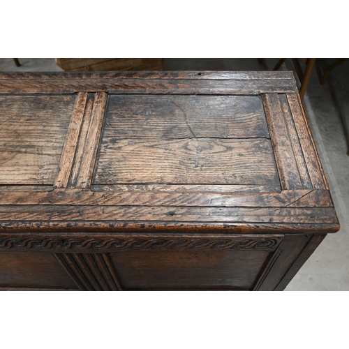 55 - An antique carved oak coffer of panelled construction, 110 cm wide x 50 cm deep x 66 cm high