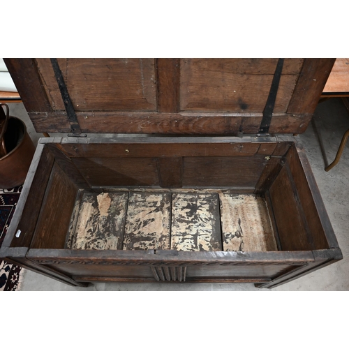 55 - An antique carved oak coffer of panelled construction, 110 cm wide x 50 cm deep x 66 cm high