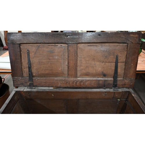 55 - An antique carved oak coffer of panelled construction, 110 cm wide x 50 cm deep x 66 cm high