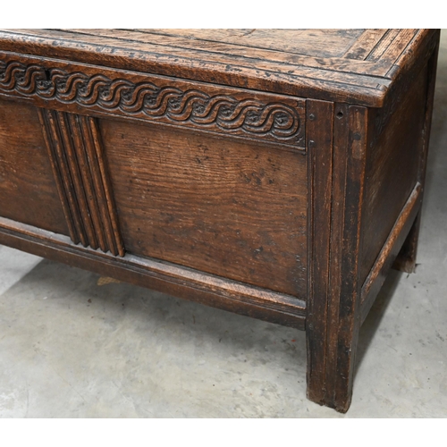 55 - An antique carved oak coffer of panelled construction, 110 cm wide x 50 cm deep x 66 cm high