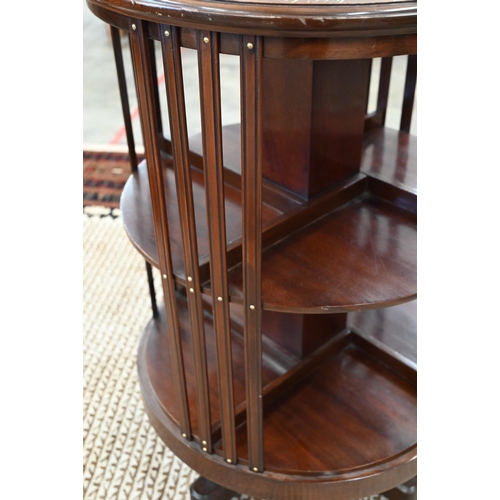 60 - A circular mahogany revolving bookcase on cruciform base with casters, 56 cm diam x 85 cm high