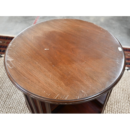 60 - A circular mahogany revolving bookcase on cruciform base with casters, 56 cm diam x 85 cm high