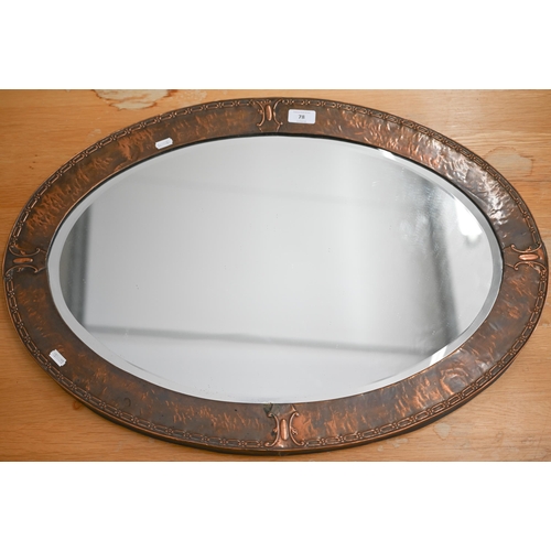 78 - An Arts & Crafts bevelled oval mirror in embossed copper frame, 72 cm wide x 50 cm high