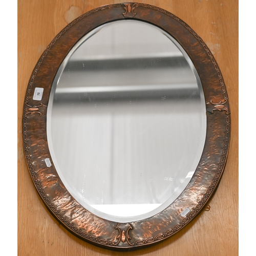 78 - An Arts & Crafts bevelled oval mirror in embossed copper frame, 72 cm wide x 50 cm high