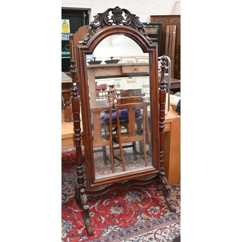 91 - A reproduction stained and carved hardwood cheval mirror, 178 cm high x 85 cm wide