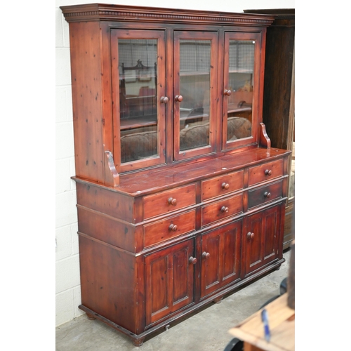 97 - A large stained pine dresser with glazed doors over six drawers and panelled cupboards in two sectio... 